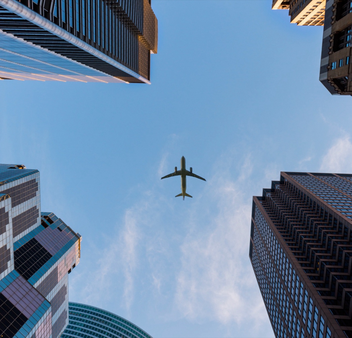 An airplane flying between city skyscrapers
