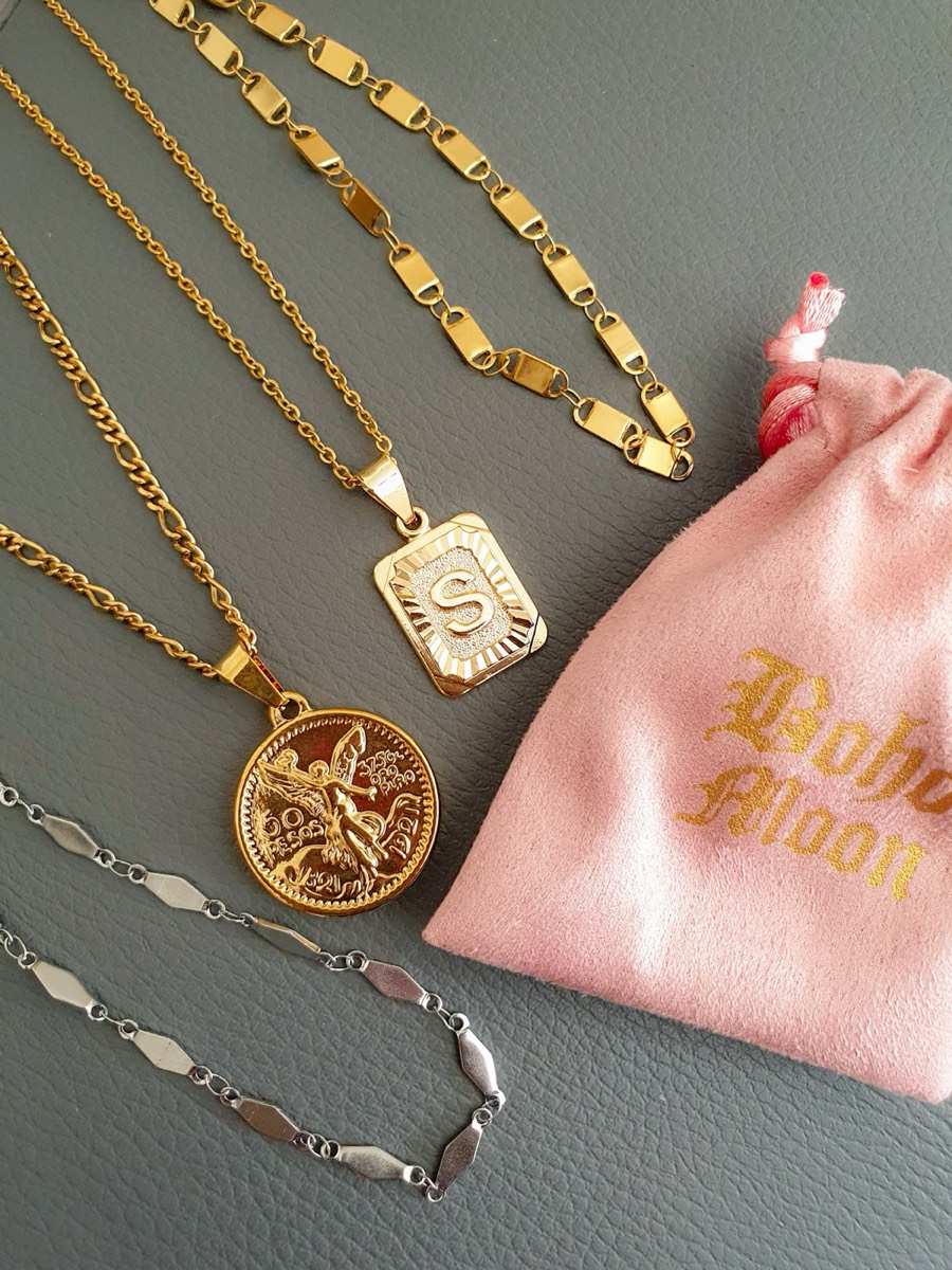 Gold Bohomoon jewellery laid on a grey surface